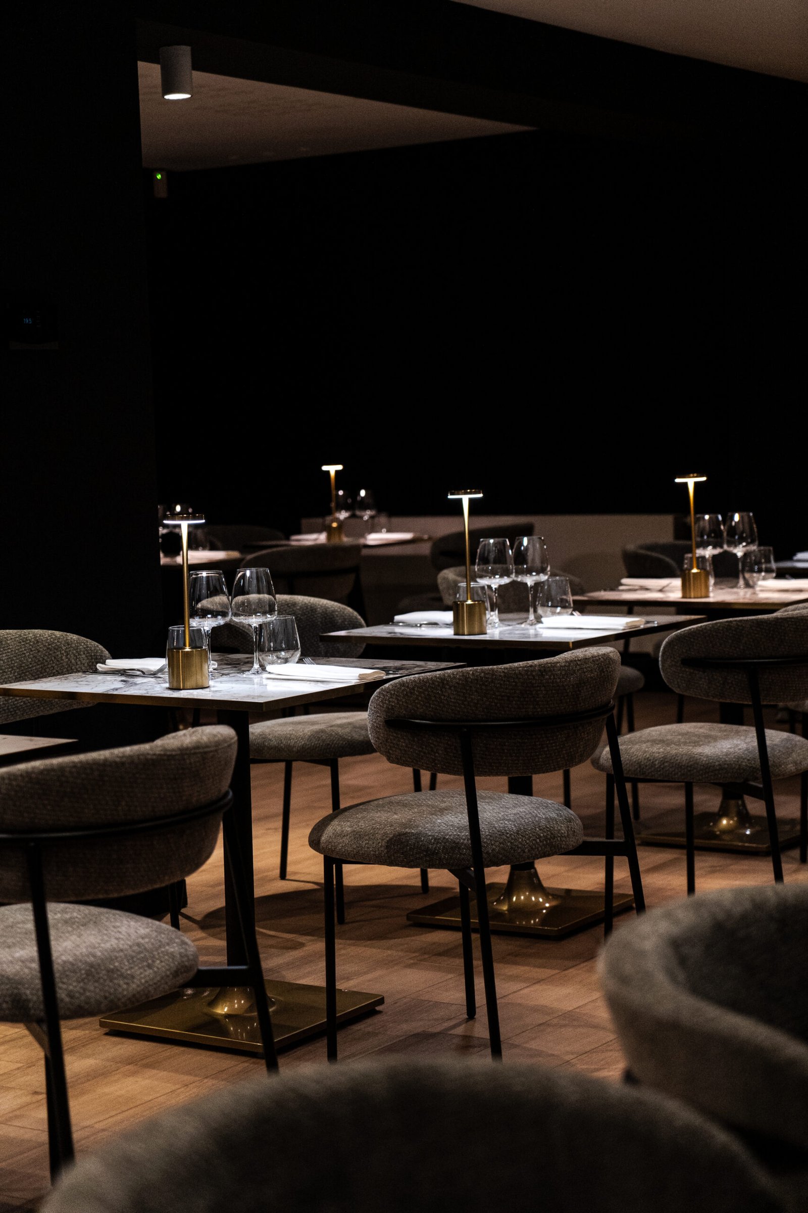 La salle du restaurant KSARA — tables en marbre, lampes dorées et fauteuils